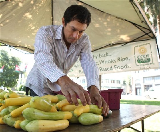 Organic farmer Luis Miranda places summer squash out for sale July 7 at a farmer's market in Sacramento, Calif. 